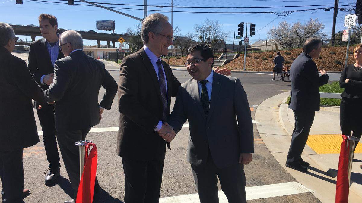 District 3 Councilman Jeff Harris and Vice Mayor Eric Guerra shaking hands after cutting a ribbon to celebrate the opening of the new Ramona Avenue Extension Friday, Feb. 22, 2019, in Sacramento State’s Lot 9.