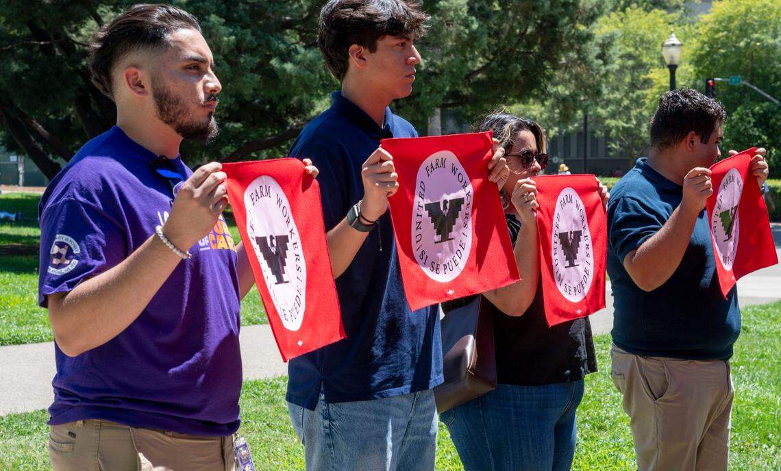 United Farm Workers’ members hold banners at a press conference outside the Capitol in support of Senate Bill 1299 on Monday. In June, six farmworkers left work with permission during triple digit heat and were fired the next day.