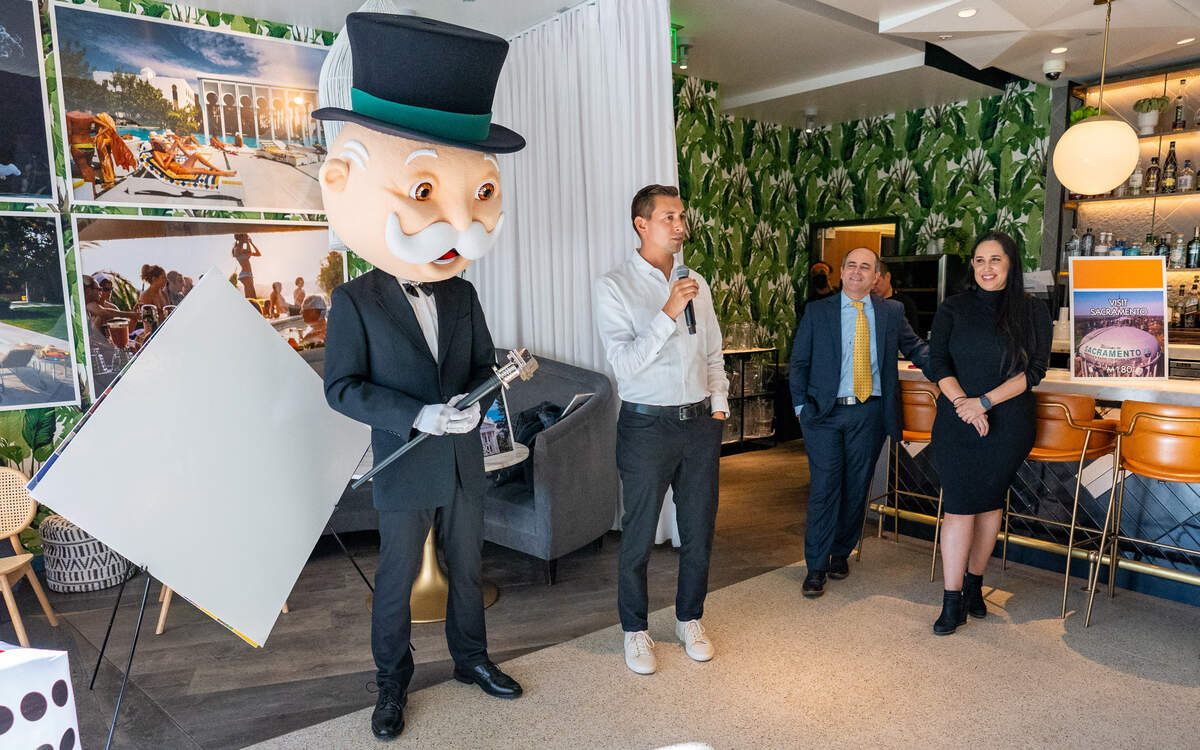 Left to right, Mr. Monopoly joined by Top Trumps USA Director of Sponsorship Aaron Green, Sacramento Kings President of Business Operations John Rinehart and Top Trumps USA Sales Representative Jennifer Tripsea prepare to show the new game board of the Monopoly Sacramento edition in the Kimpton Sawyer Hotel on November 15, 2022.