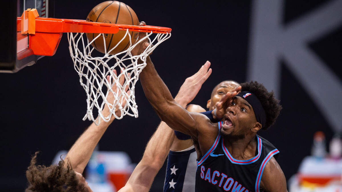 Sacramento Kings forward Terence Davis (9) dunks the ball with force as Washington Wizards guard Russell Westbrook (4) makes contact from behind, and center Robin Lopez (15) defends at left, during the fourth period of the NBA game Wednesday, April 14, 2021, at Golden 1 Center in downtown Sacramento. A delay of game was called against the Kings after the play on the way to the Wizards’ 123-111 win.