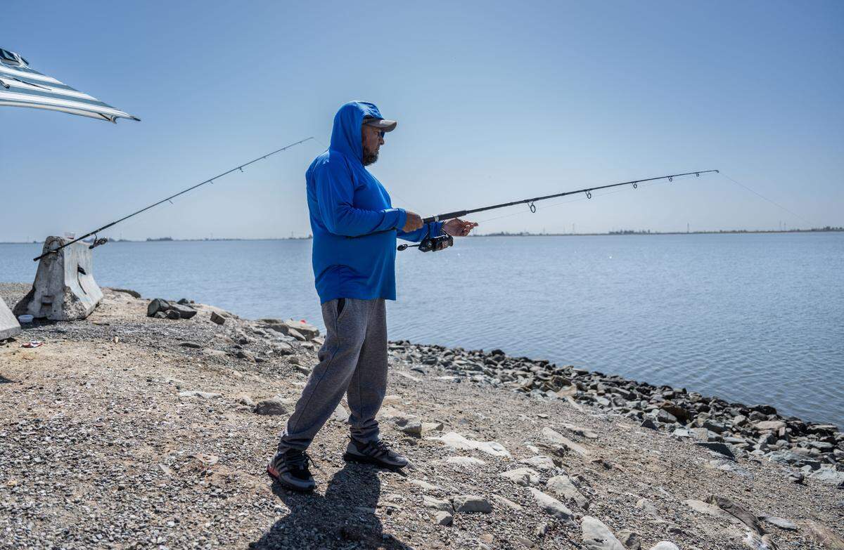 Miguel Gonzales of San Jose fishes in the Clifton Court Forebay near the John E. Skinner Delta Fish Protective Facility on Wednesday. The forebay is filled with nonnative striped bass and other predator fish that feed on juvenile salmon, steelhead trout and other native species.
