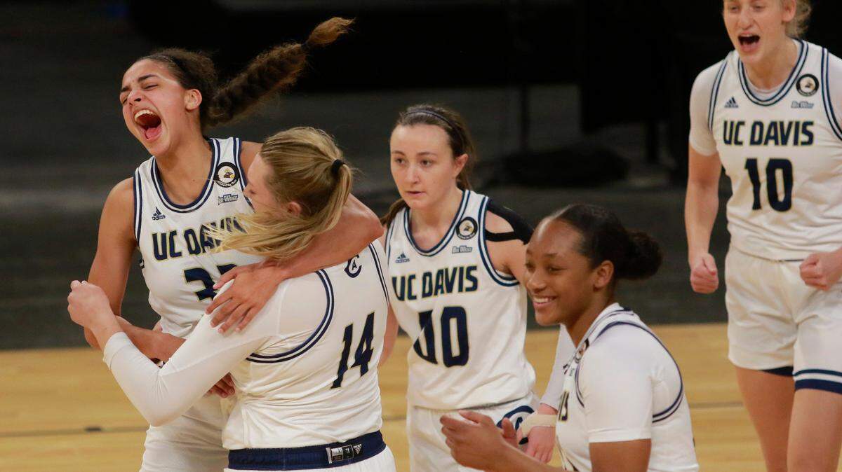 UC Davis’ Cierra Hall (32), far left, celebrates with teammate UC Davis’ Emma Gibb (14) after they won an NCAA college basketball game against UC Irvine in the championship of the Big West Conference tournament Saturday, March 13, 2021, in Las Vegas. (AP Photo/Ronda Churchill)