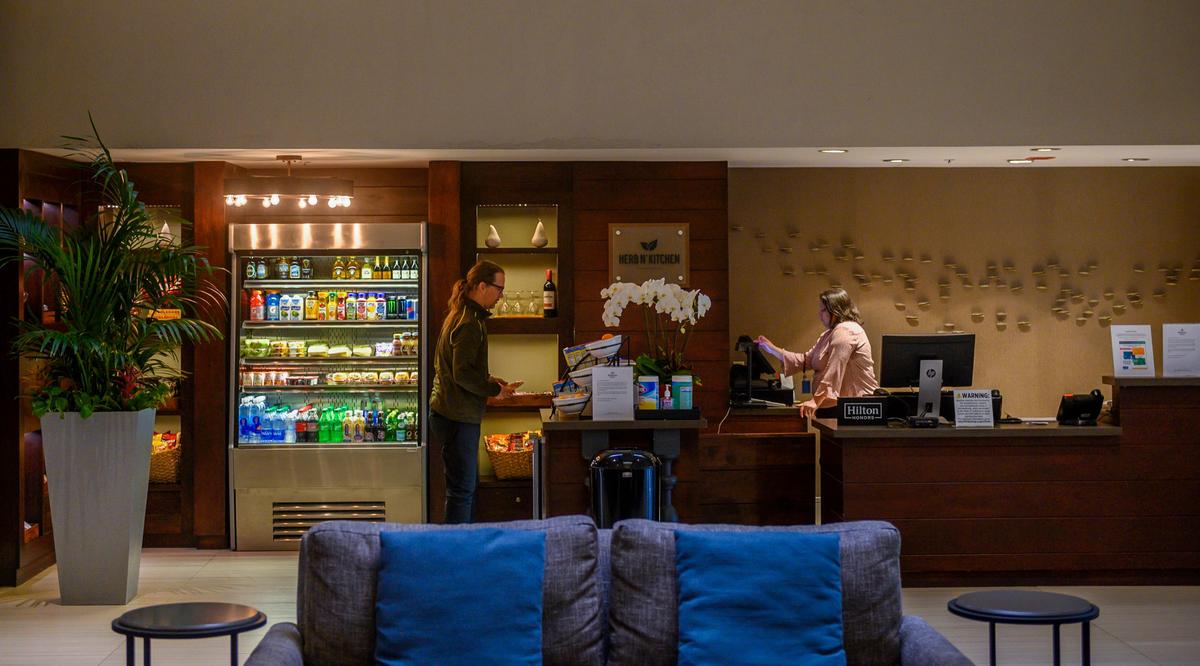 A customer buys a snack at the front desk at the Hilton Arden West on Thursday, March 26, 2020. General Manager Sami Qureshi says that the hotel is now running at 19-20 percent occupancy down from its typical 85-88 percent occupancy.