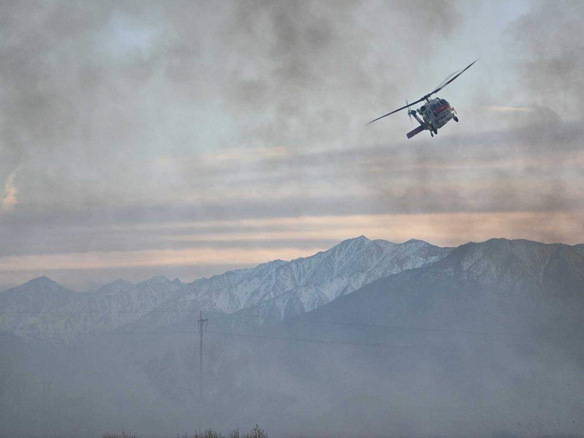 A Cal Fire helicopter flies above the Silver Fire, which has burned roughly 1,250 acres near Bishop and was 0% contained on Monday, March 31, 2025.