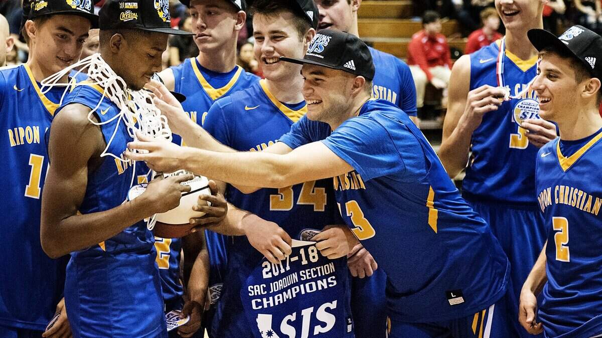 Ripon Christian players prepare for a team photo after winning the Sac-Joaquin Section DVI championship game against Sacramento Adventist at Pacific in Stockton, on Thursday.