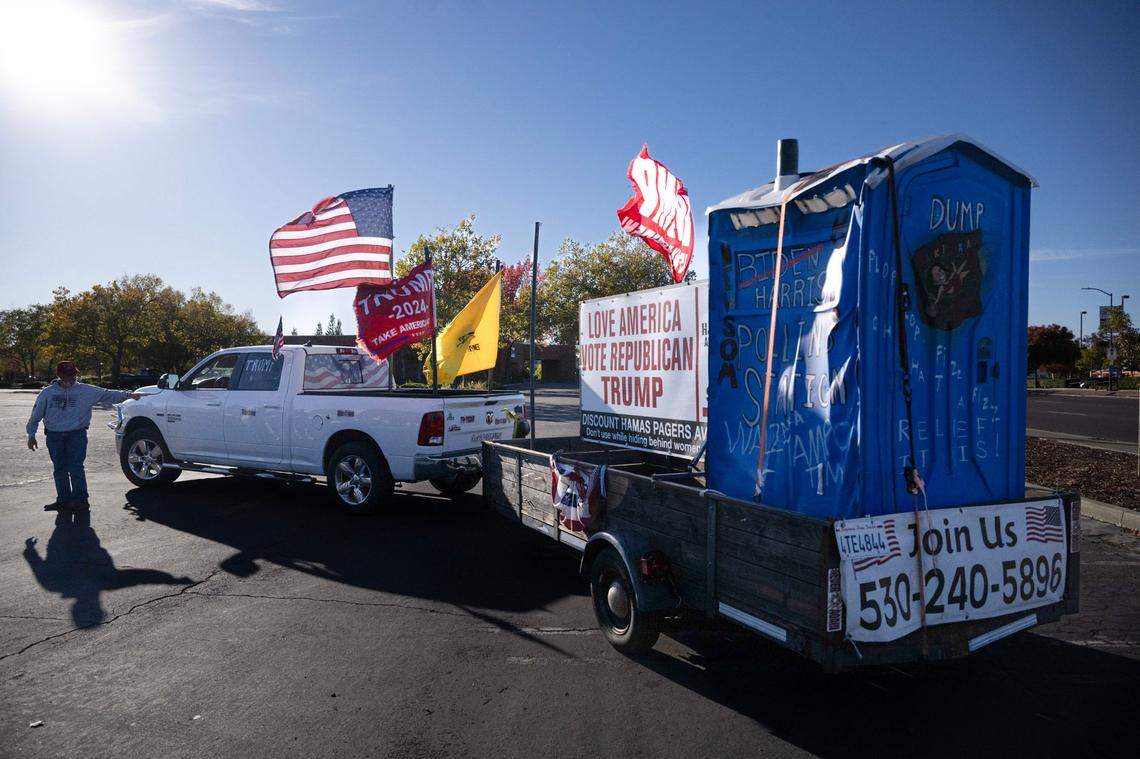Steve of Pollock Pines, who asked that his last name not be used, waits Wednesday for the start of a caravan celebrating President-elect Donald Trump at Sunrise Mall in Citrus Heights. His truck tows a trailer carrying a port-a-potty that reads “Harris-Walz voting booth.”