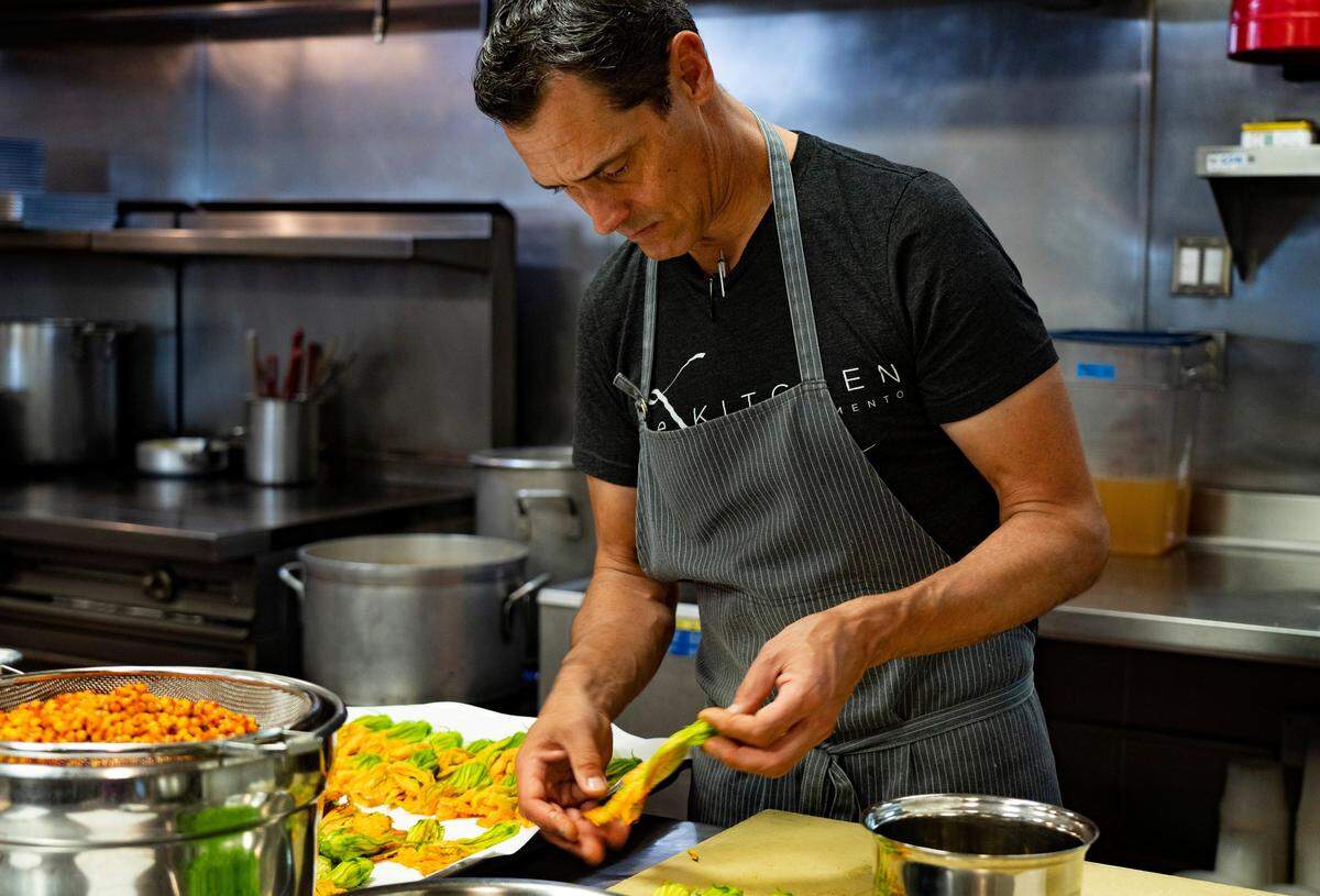 Executive chef Kelly McCown prepares squash blossoms for dinner service at The Kitchen on June 5, 2019. The blossoms will be filled with huitlacoche, also known as Mexican corn truffle, and will be served with smoke-roasted mole-spiced beef short ribs.