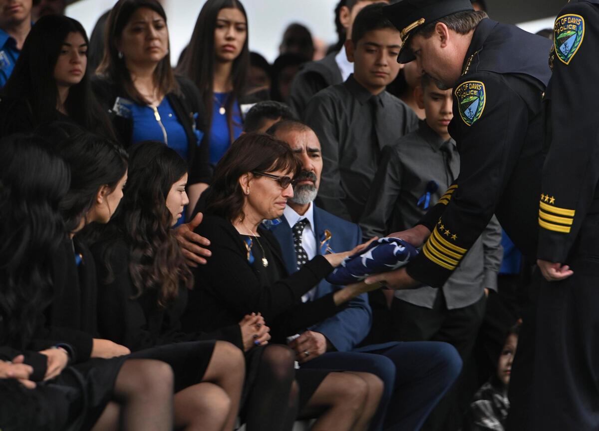 Lupe and Merced Corona, parents of fallen Davis police officer Natalie Corona, receive the flag that covered her casket during the burial services Friday.