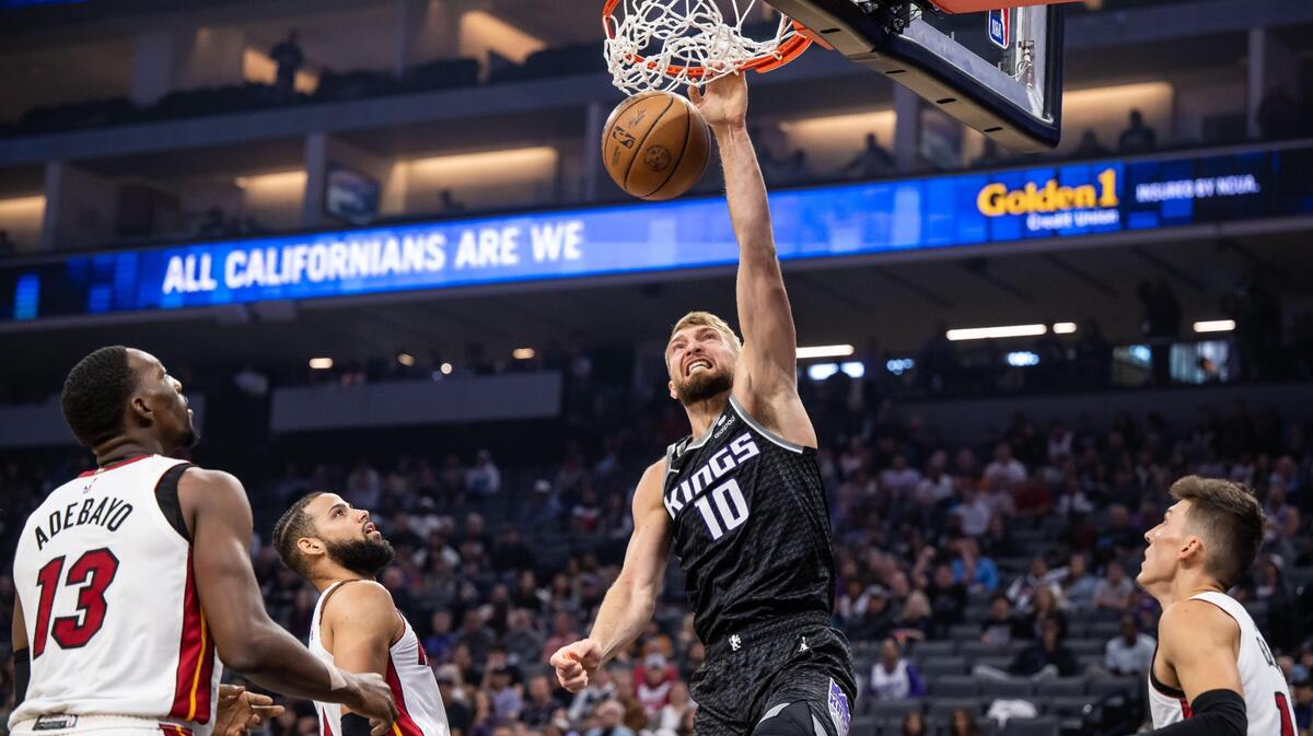 Sacramento Kings center Domantas Sabonis (10) has a put-back slam dunk off an attempted shot by guard De’Aaron Fox (5), as Miami Heat forward Caleb Martin (16) looks up at left, during opening moments of the first quarter at the NBA basketball game Saturday, Oct. 29, 2022, at Golden 1 Center in Sacramento.