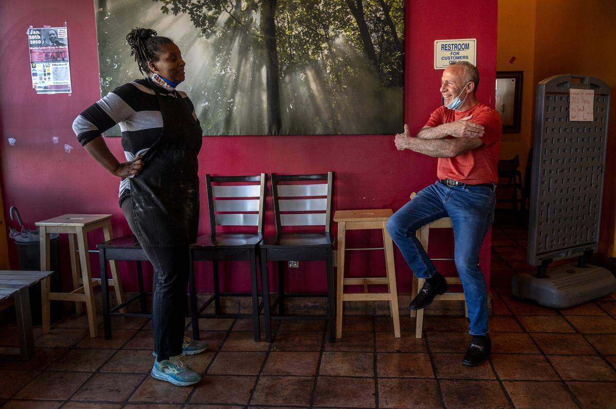 Mayor Darrell Steinberg gestures a hug to Tamar McCree, owner of Coco’s Soul Kitchen in Sacramento, while waiting on April 23 for his take-out lunch of fried chicken in support of restaurants during the coronavirus pandemic. “I’m sending you a virtual hug, it’s going to be okay,” said Steinberg, after listening to McCree’s concerns.