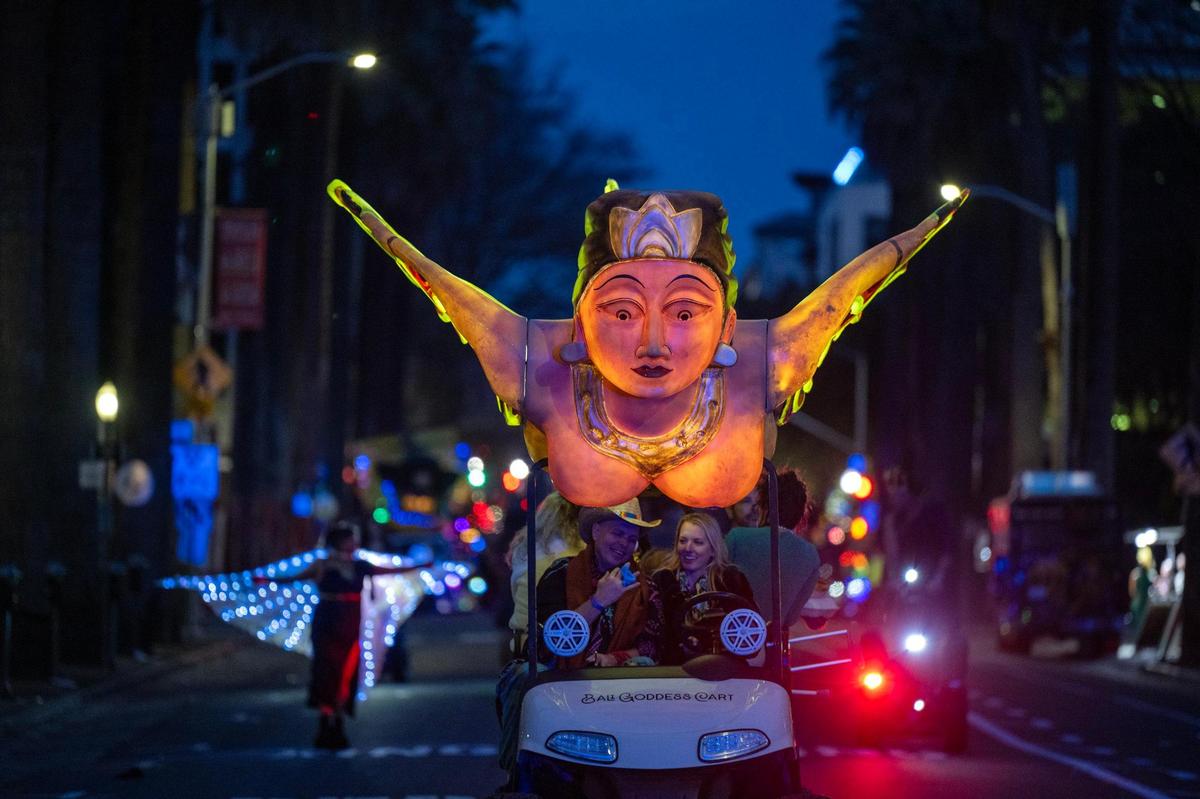 April Robinson and Clint Willett ride in a float with a sacred goddess of fertility at the City of Trees Parade as Sacramento celebrates Mardi Gras on Saturday.