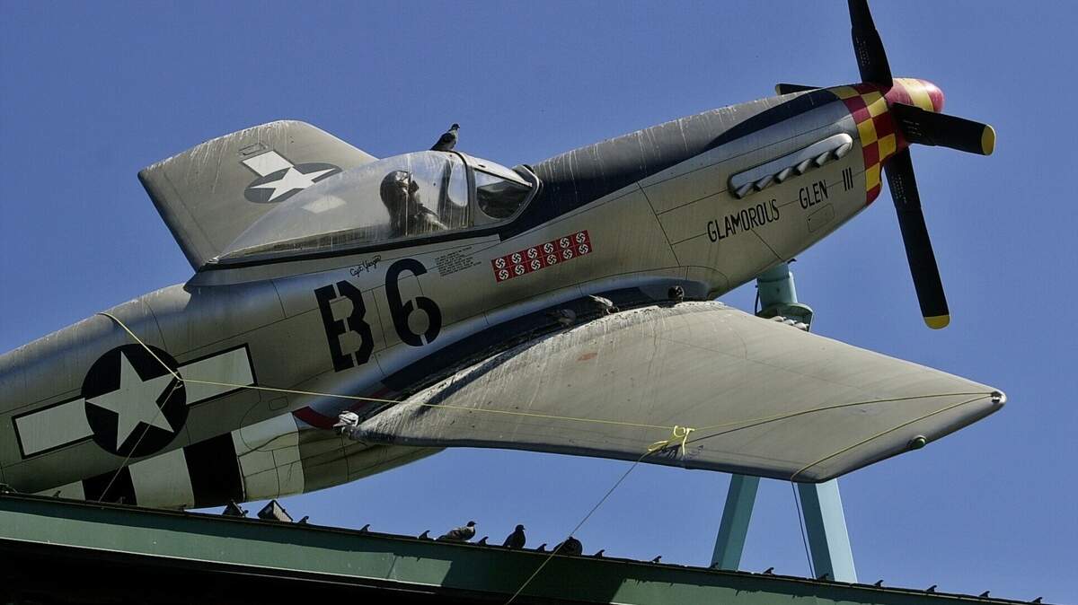 The damaged wing of a fighter plane replica on a tower above the Aces Supper Club at the Holiday Inn on Date Road in Foothill Farms is secured with a rope on Sept. 5, 2003, before its removal to assess structural problems. The parking lot entrance and the main entrance to the night club were closed as precautions.