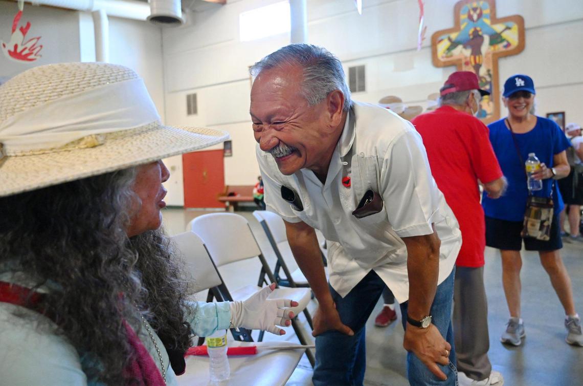 Former UFW President Arturo Rodriguez, center, smiles as he chats with current UFW President Teresa Romero, left, as the marchers in the UFW’s March For The Governor’s Signature gather for a break from the heat in a church in Calwa on Aug. 11.