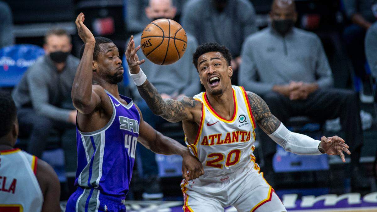Sacramento Kings forward Harrison Barnes (40) defends against Atlanta Hawks forward John Collins (20) during the first half of an NBA basketball game in Sacramento, Calif., Wednesday, March 24, 2021. (AP Photo/Hector Amezcua)