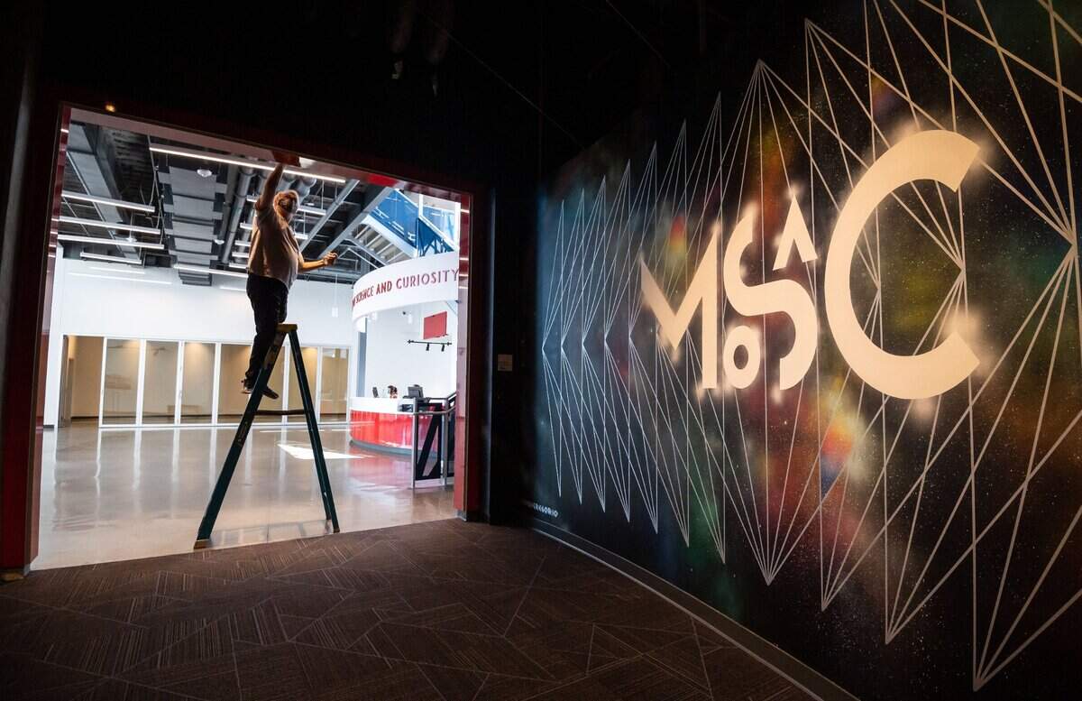 Building maintenance employee Dorian Adkins, of Sacramento, polishes an entryway featuring a mural by Jose Di Gregorio in the SMUD Museum of Science and Curiosity on Sept. 9.