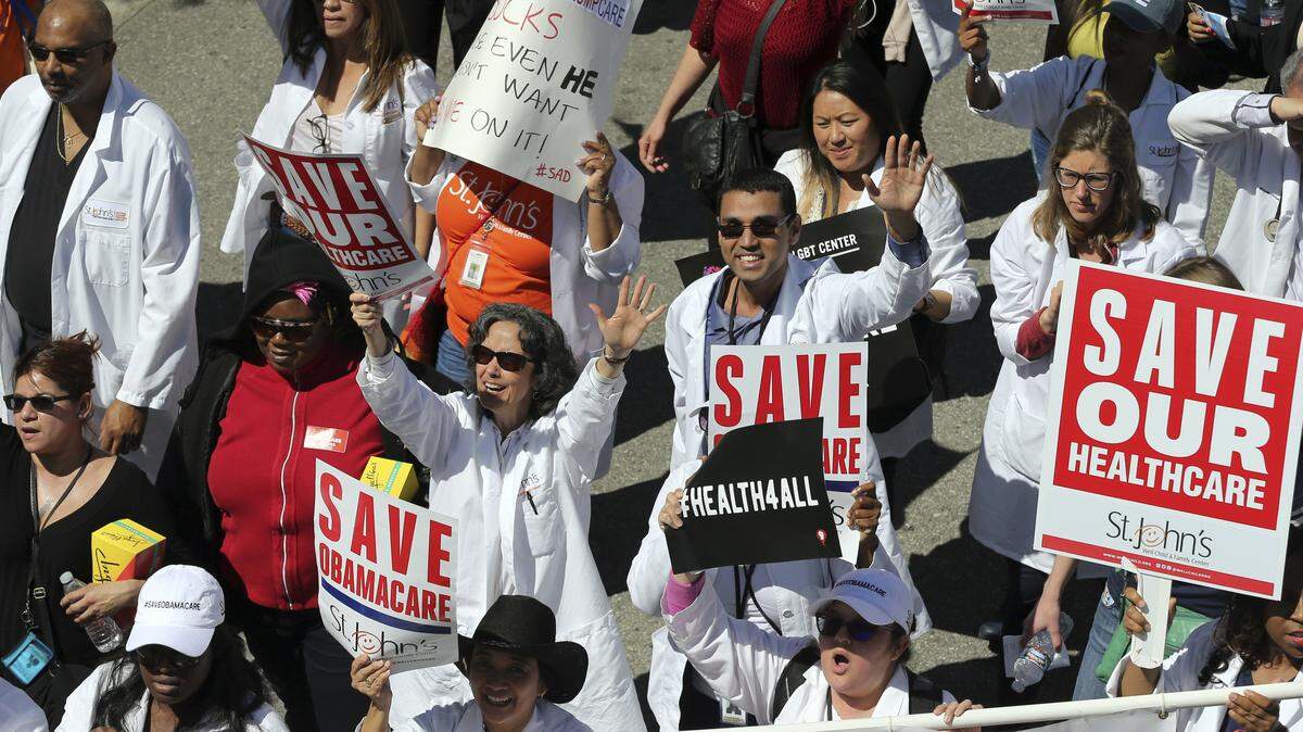 In this March 23, 2017, file photo, health care professionals join hundreds of people marching through downtown Los Angeles protesting a plan from President Donald Trump to dismantle the Affordable Care Act.