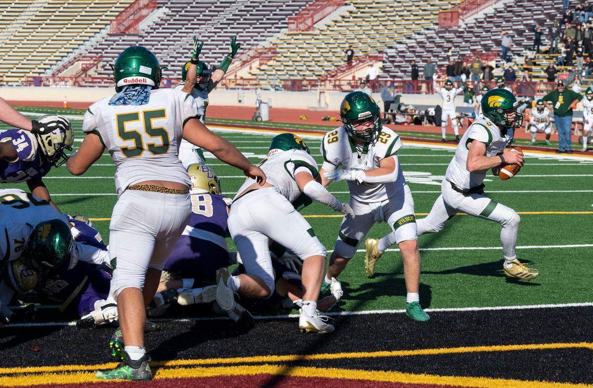 Sonora Wildcats quarterback Eli Ingalls (5) runs a keeper around the edge of the Bradshaw Christian defense to score the game-winning touchdown on a fourth and inches play in the 2024 Sac-Joaquin Section Division VI championship game at Hughes Stadium.