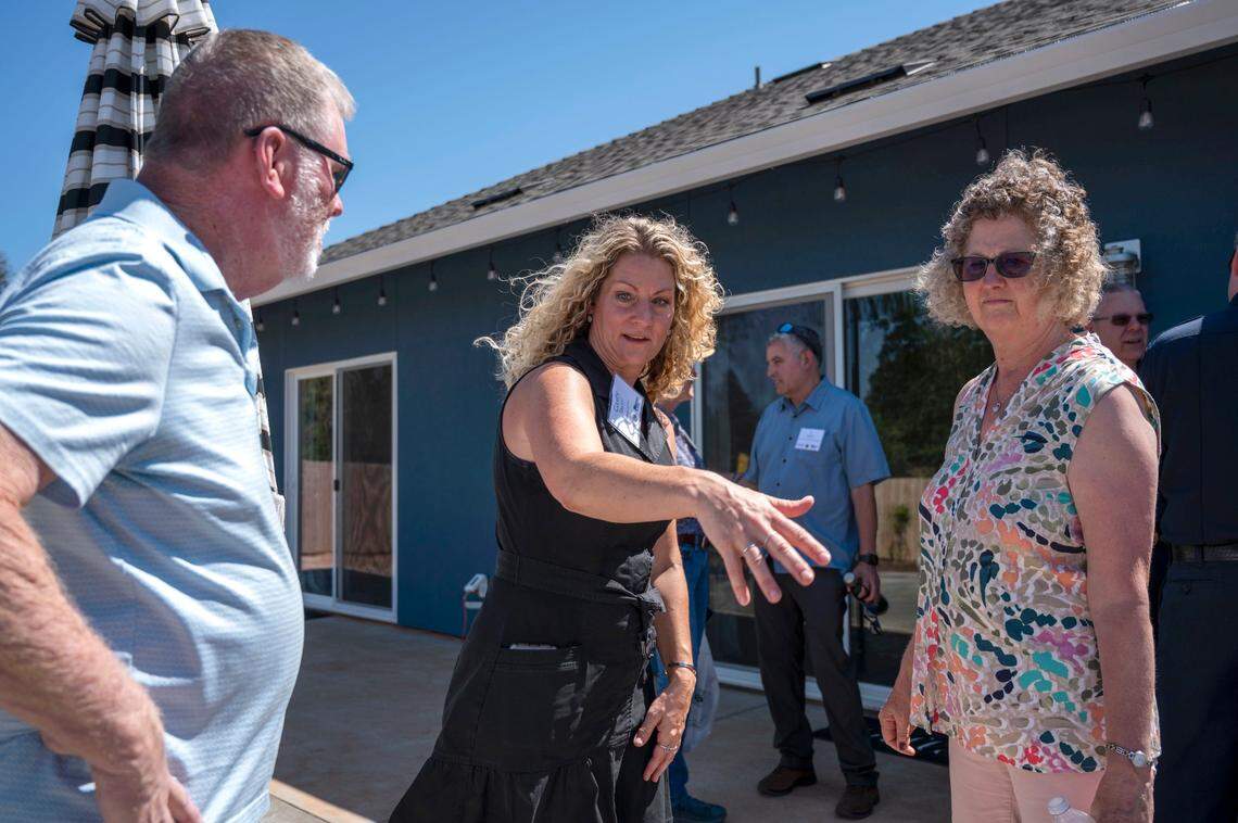 Paradise resident Casey Taylor, center, talks to City Councilwoman Judy Jones, right, who was the mayor when the Camp Fire burned the town in 2018, and Judy’s husband Ron Jones on Wednesday. Taylor’s home was designated as the first Wildfire Prepared Home in the country.