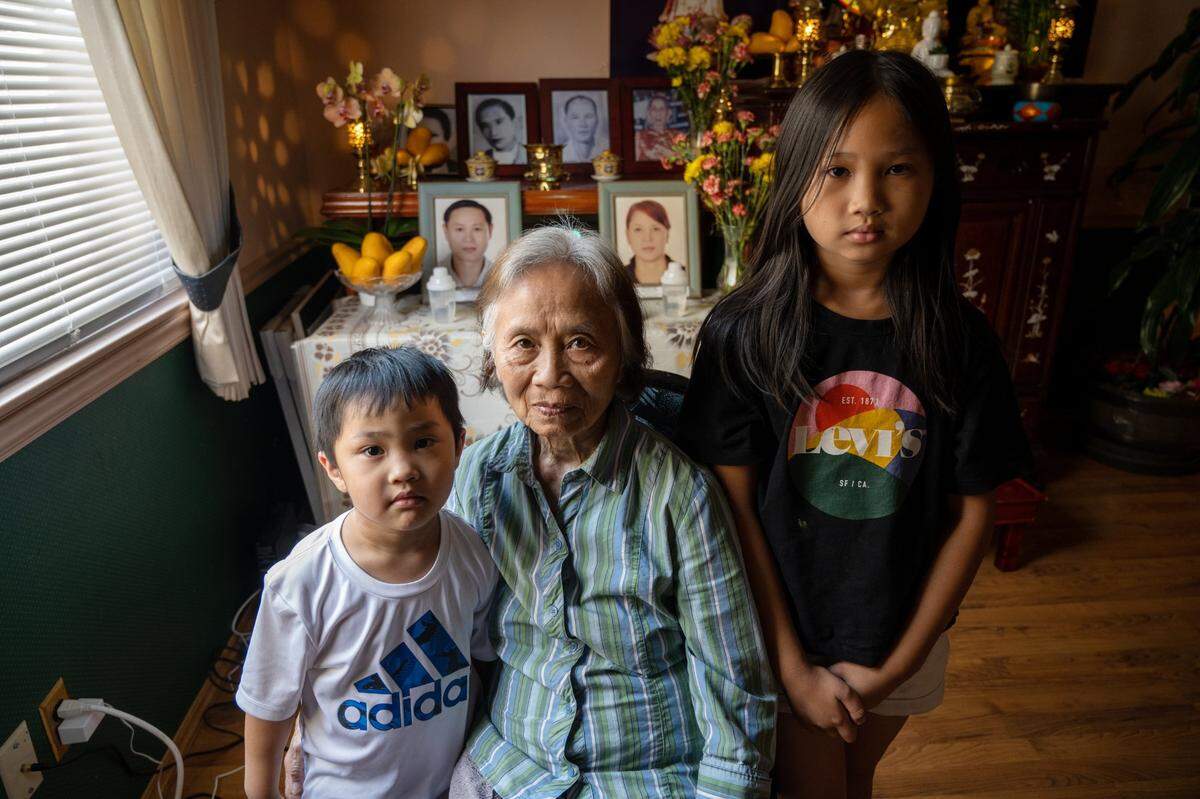 Phuong Hoang, 80, sits with her grandchildren Johnny, 5, and Cathy Nguyen, 8, at her Sacramento home on July 25. Hoang said that Cathy doesn’t want anyone to see that she’s sad about the death of her parents, who were killed by a suspect fleeing Sacramento police, in May.