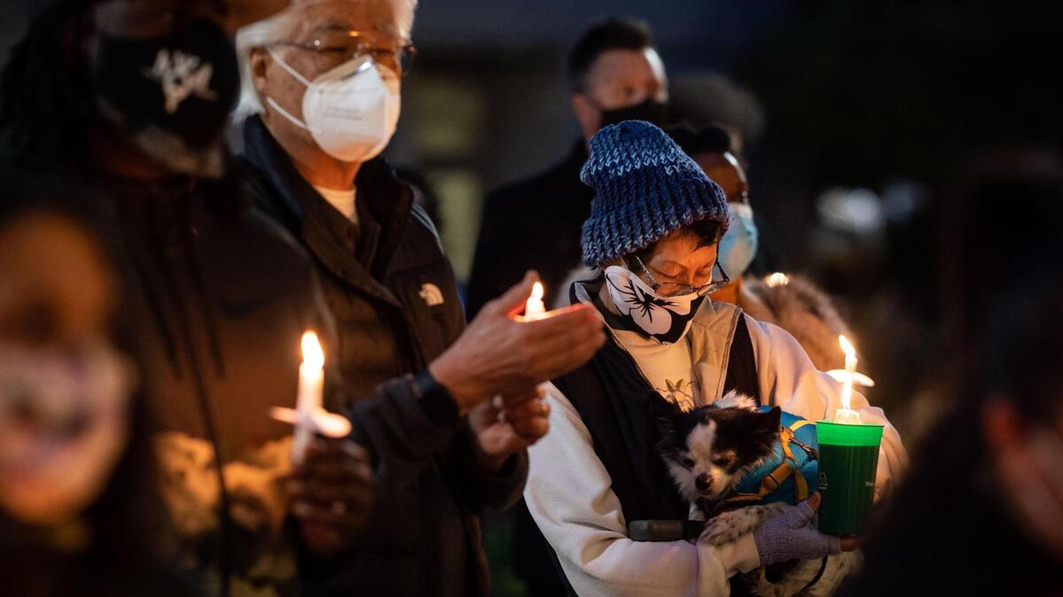 May Lee, of Sacramento, holding her dog Neptune, attends a candlelight vigil in front of Sacramento City Hall on Wednesday, March 17, 2021, to honor the victims from Tuesday’s shootings in Atlanta. The vigil, organized by Asian American and Pacific Islander community members, was attended by various groups and people in solidarity with Asian women in the wake of the mass shooting.