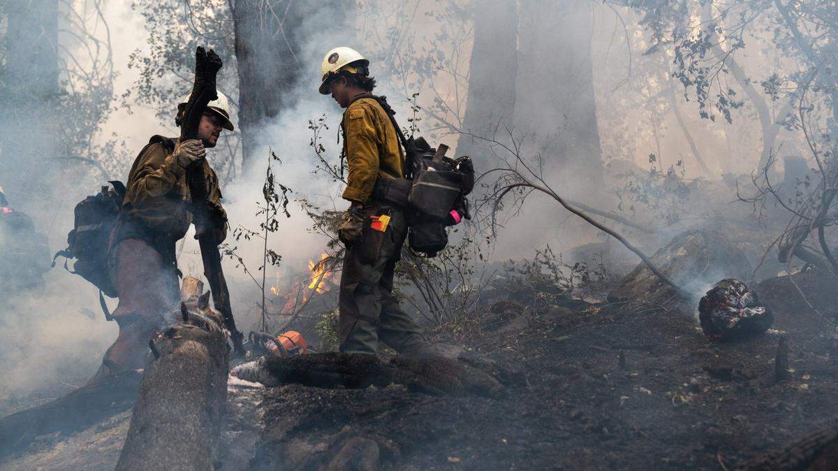 El Dorado County firefighters protect a home on Snowflake Drive in Christmas Valley during the Caldor Fire on Tuesday, August 31, 2021, in El Dorado County.