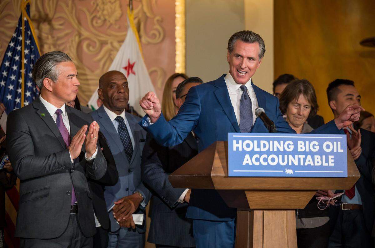 Gov. Gavin Newsom is surrounded by legislators and state officials — including state Attorney General Rob Bonta, left, and state Sen. Nancy Skinner, D-Berkeley, right — as he speaks before signing a bill at the Capitol on March 28, 2023, aimed at addressing gas price gouging.