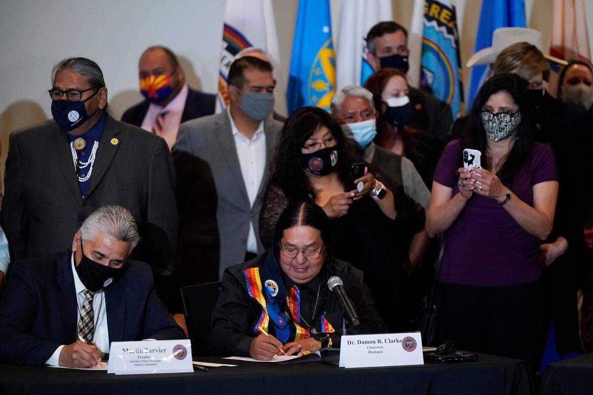 Martin Jarvier, of the Salt River Pima-Maricopa Indian Community, front left, and Damon R. Clarke, of the Hualapai Tribe, front right, join a bill signing allowing a major expansion of sports betting in Arizona in April. The measure approved by the Legislature adds additional types of table games at tribal casinos and for the first time allows sports betting under licenses issued to tribes and pro sports teams.