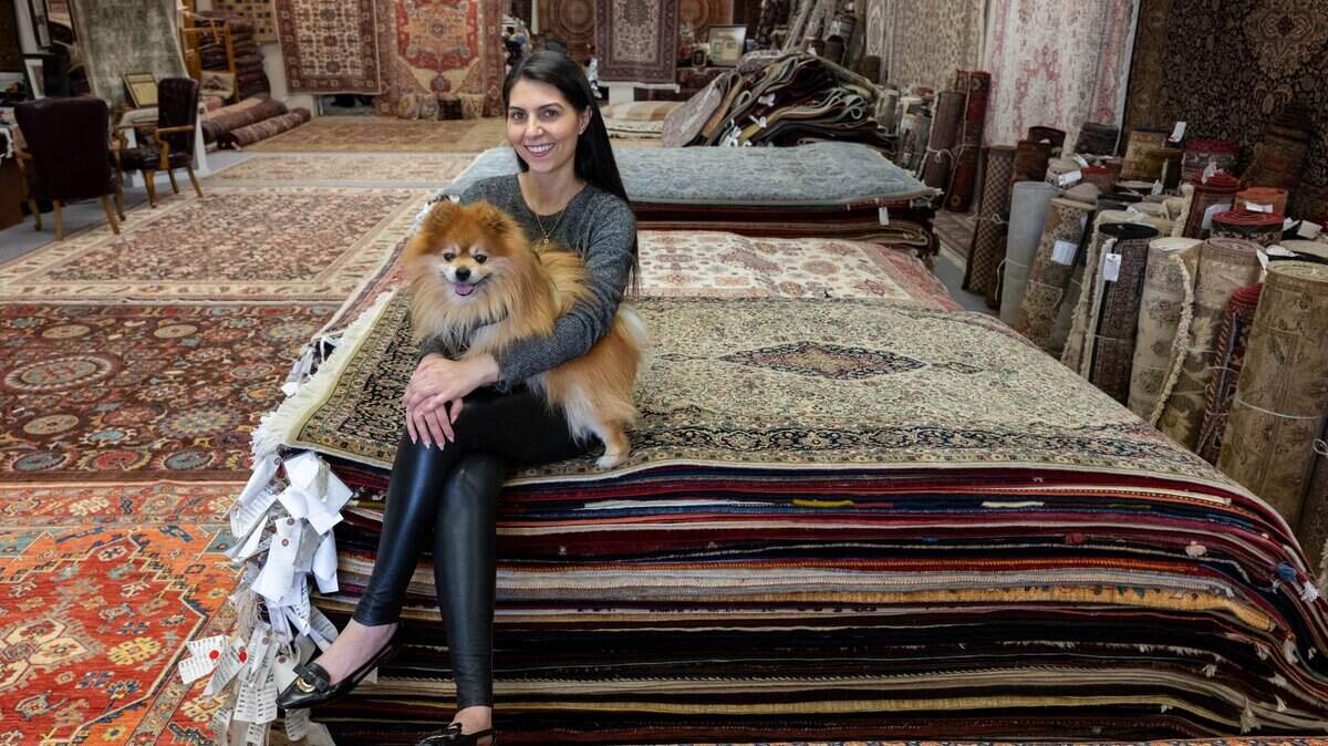 Rebecca Yaghoubian sits among thousands of carpets with her dog, Teddy, at Mansour’s Oriental Rug Gallery in Arden Arcade on Tuesday. The family-owned business is closing its Fair Oaks Boulevard location after nearly 50 years, while maintaining a second store in Roseville.