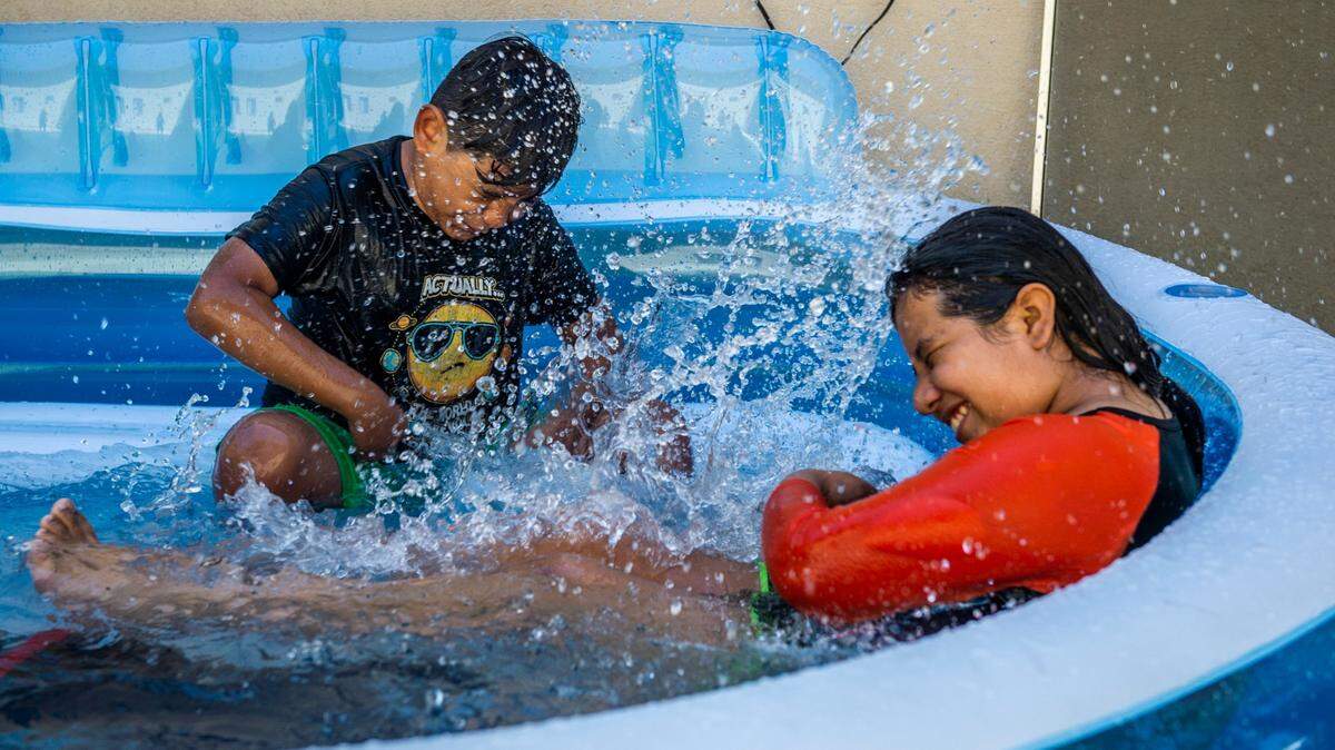 Marioune Peña, 11, has a water fight with cousin Efrain Reyes, 9, during a hot summer day in 2020 in Rancho Cordova.