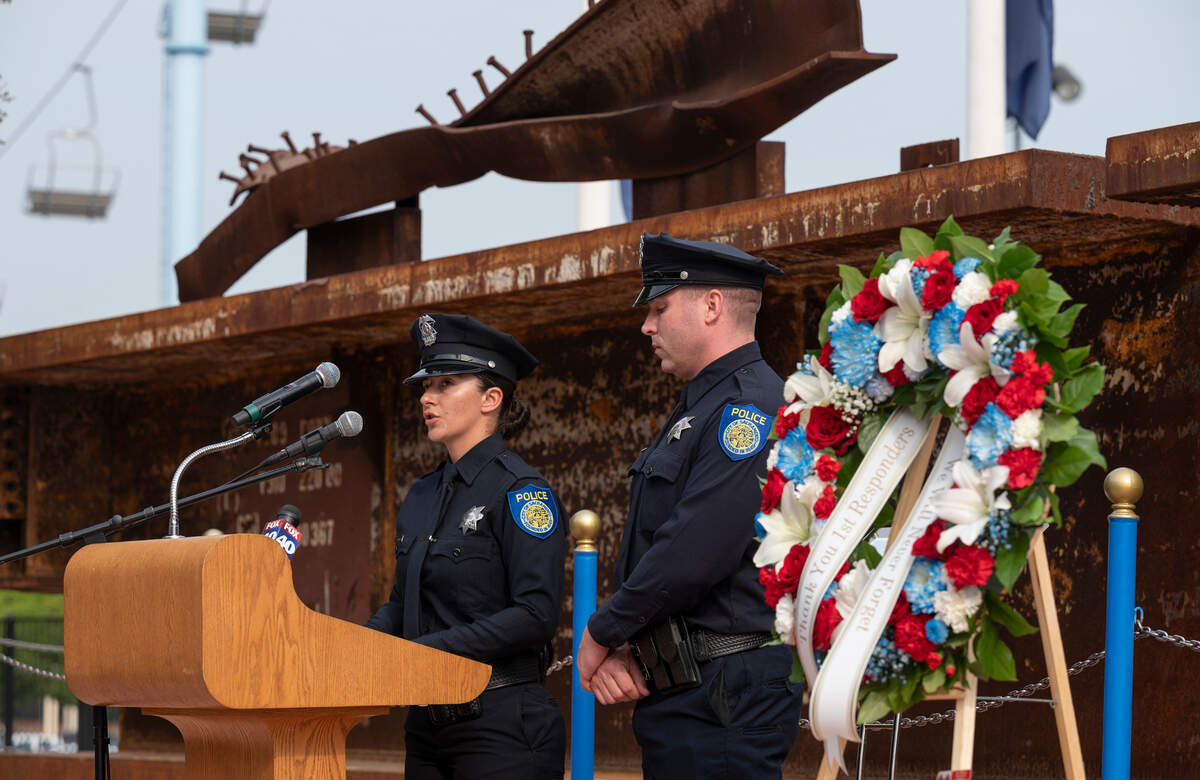 Sacramento Police Officer Jessica Cummings reads names of New York police who died at ground zero, while standing in front of a twisted steel beam from the World Trade Center, with Officer Michael Mantsch during a Sunday ceremony remembering the events of 9/11 at Cal Expo’s September 11 Memorial Plaza.