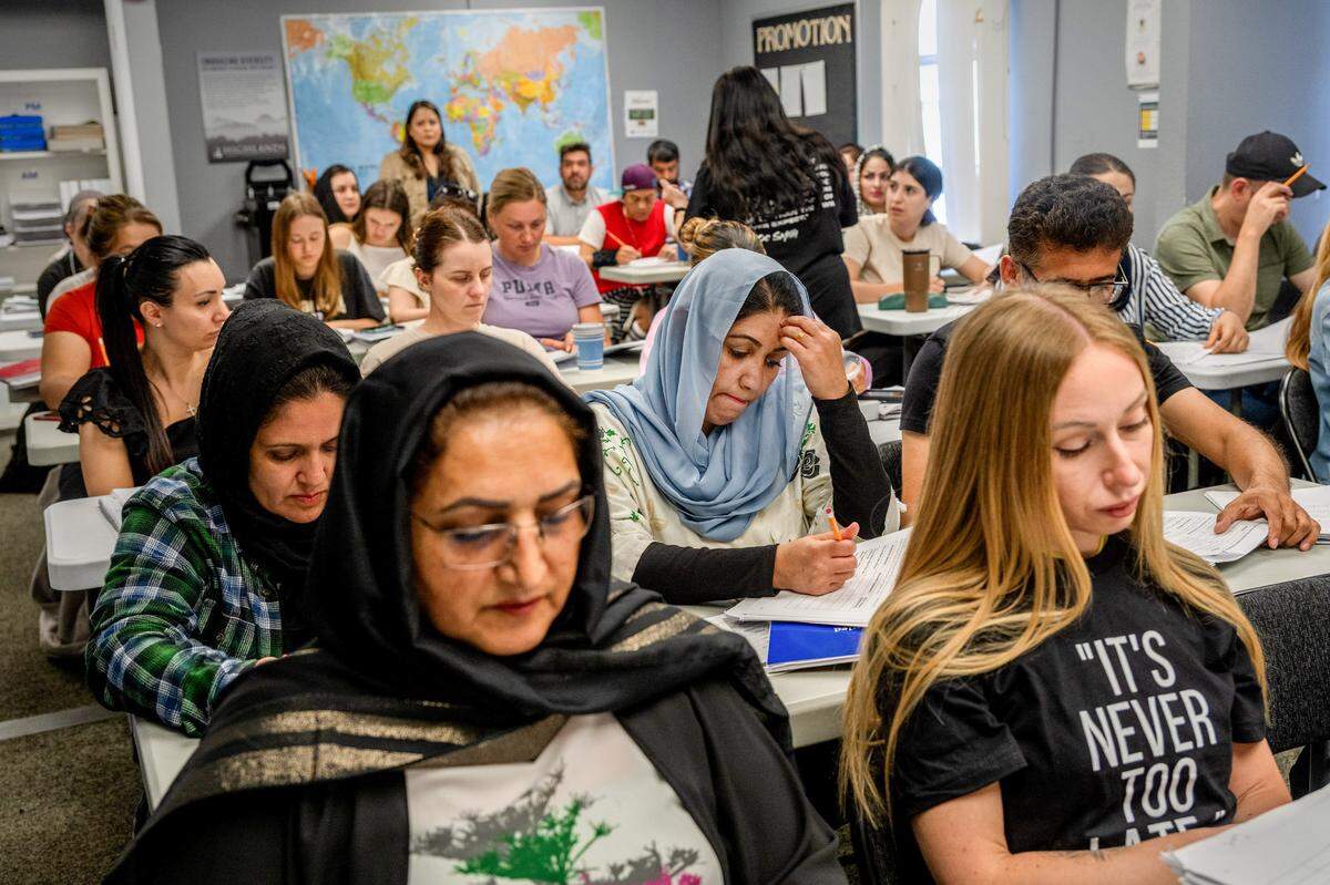 Fahima Nazari, 29, center, an Afghan refugee wearing a blue hijab, concentrates during an ESL class at Highlands Community Charter’s Grand Avenue campus in Sacramento last month. Her husband worked with the U.S. military and received a Special Immigrant Visa. Now they worry that if the school closes, their hopes for education, employment and supporting their family will be at risk.