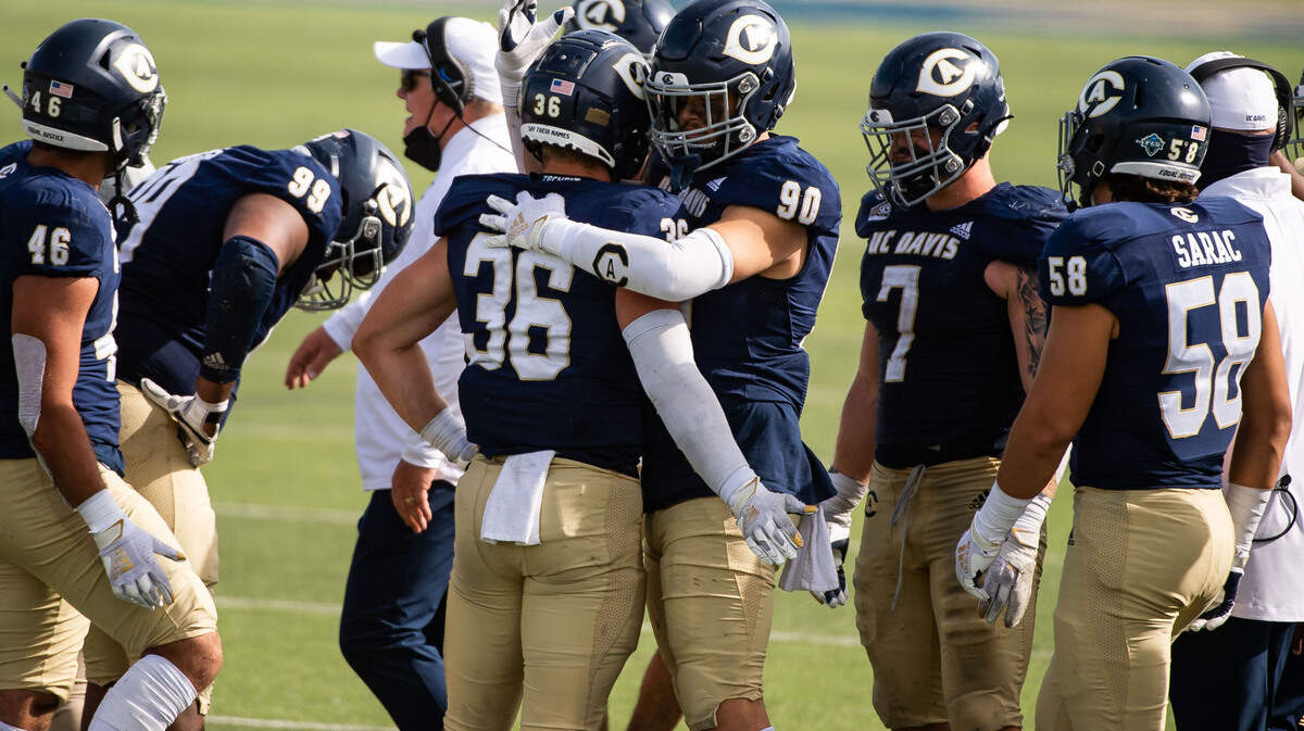 UC Davis Aggies defensive lineman Cade Peacock (90), right, hugs UC Davis Aggies linebacker Connor Airey (36) as their loss to Eastern Washington becomes clear during the fourth quarter of the college football game Saturday, April 3, 2021, at UC Davis Health Stadium.