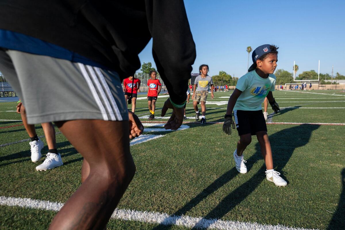 Riley Beverly, 6, participates in defensive drills during the Spencer Webb Youth Football and Cheer Camp on Wednesday at Christian Brothers High School.