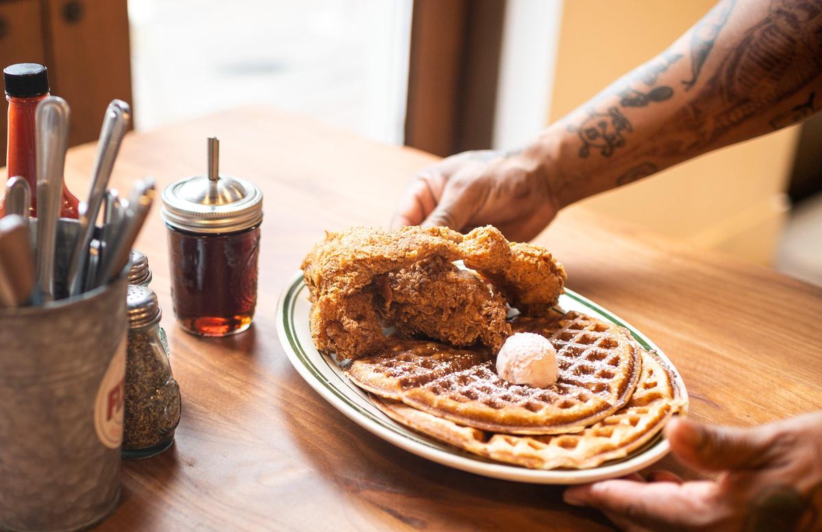 The chicken and waffles breakfast, served all day, is placed on a table at Fixins Soul Kitchen in Sacramento’s Oak Park neighborhood.
