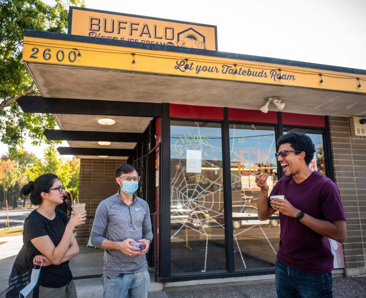 Christopher Kelly, right, of San Jose, enjoys Cornflower Creamery ice cream with friends Sebastian Leon, middle, and Selina Sotomayor at Buffalo Pizza & Ice Cream Co. in Sacramento’s Curtis Park neighborhood on Sunday, Nov. 1, 2020.