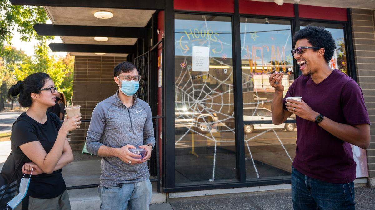 Christopher Kelly, right, of San Jose, enjoys Cornflower Creamery ice cream with friends Sebastian Leon, middle, and Selina Sotomayor at Buffalo Pizza & Ice Cream Co. in Sacramento’s Curtis Park neighborhood on Sunday, Nov. 1, 2020.