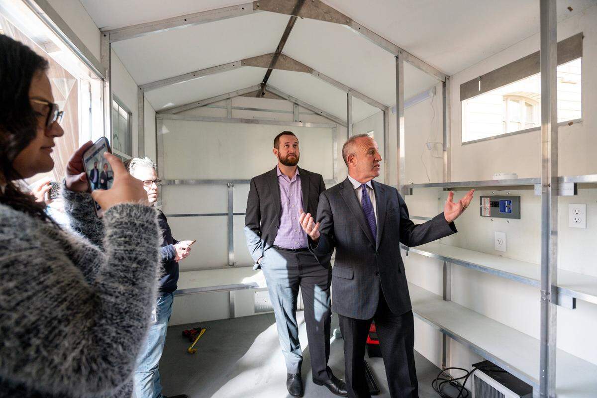 Sacramento Mayor Darrell Steinberg shows enthusiasm about the potential for housing people who are homeless in Sacramento inside shelters made by the Washington-based company Pallet, while Councilman Steve Hansen, rear, helps facilitate a demonstration outside Sacramento City Hall on Nov. 13, 2019.