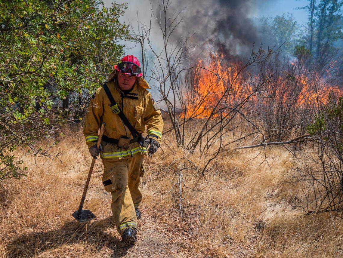 A Sacramento firefighter responds to a fire on the American River Parkway last July. Approximately 15% of the parkway’s 4,800 acres burned last year, according to the American River Parkway Foundation.