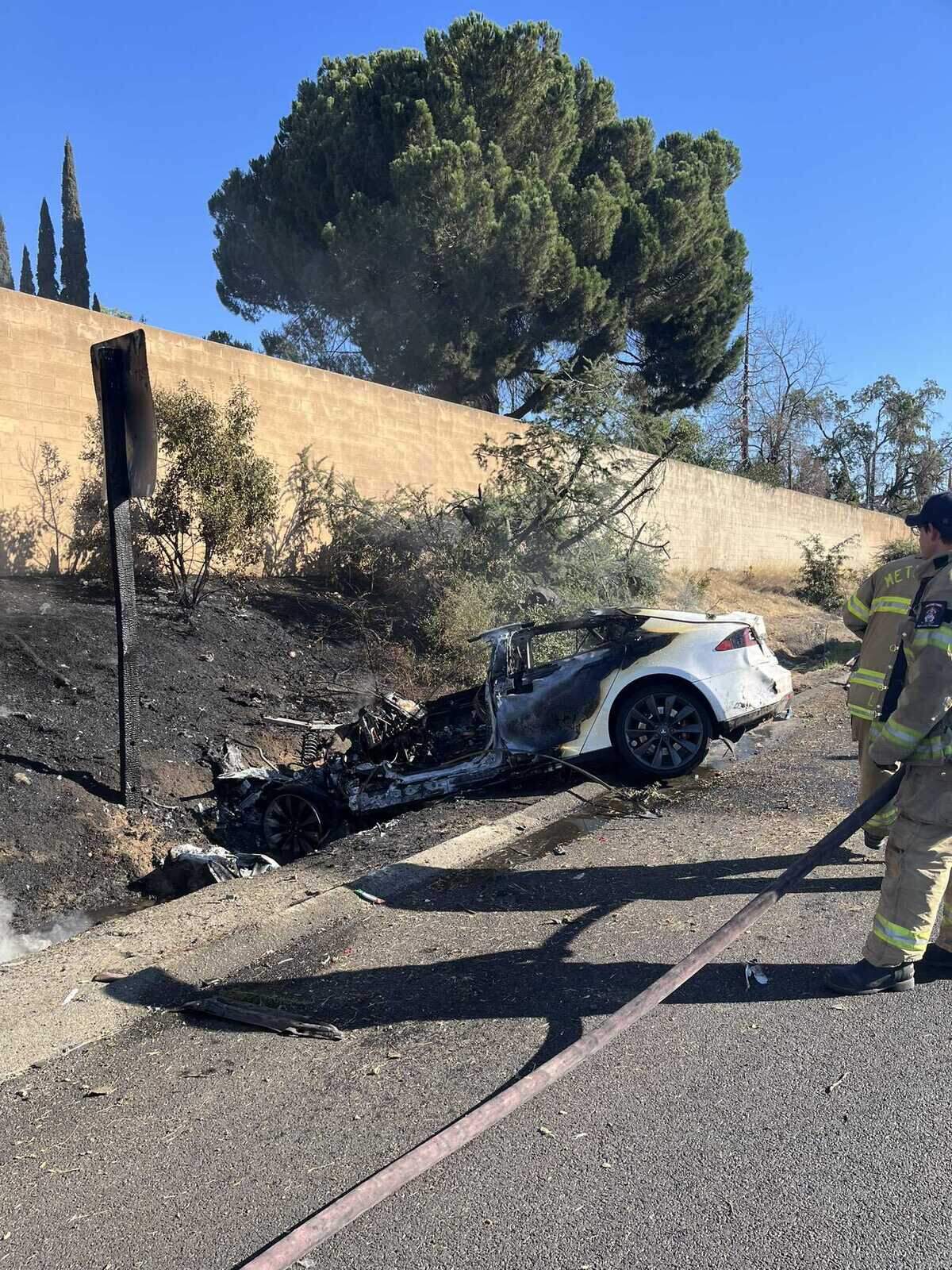 Sacramento Metropolitan Fire District personnel tend to a fire sparked from a Tesla electric car on Monday, Aug. 15, 2022. The driver of the vehicle was hospitalized.