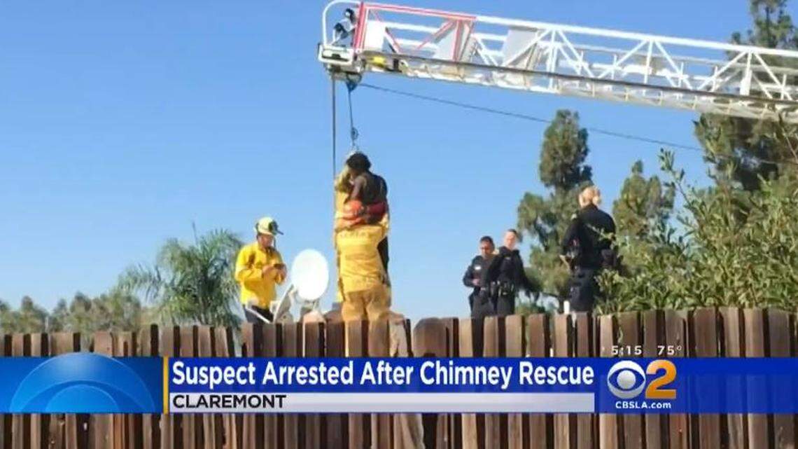 Firefighters pull Michael Arciniega, 24, from a chimney in Claremont, California, on Saturday morning after he became stuck overnight trying to break in, police said.