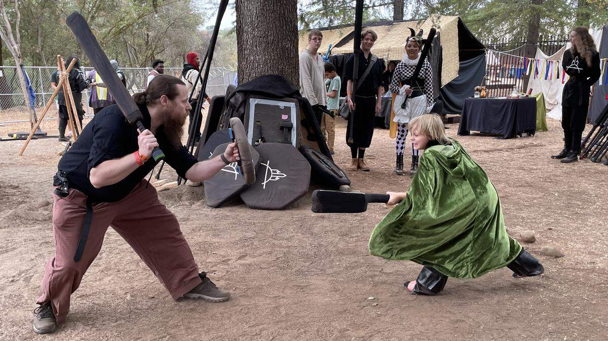 Joe Deaton, 39, and his stepson Soren Olafsen, 8, of Natomas, practice sword fighting at the Folsom Renaissance Faire on Sunday, Sept. 28, 2025.