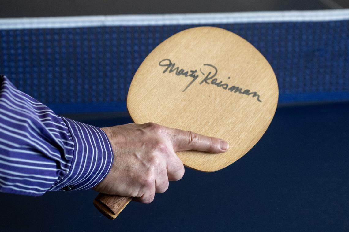 Scott Gordon holds an autographed paddle, given to him by table tennis star Marty Reisman, at his home earlier this month. 