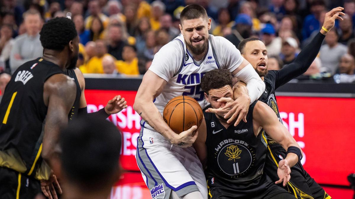 Sacramento Kings center Alex Len (25) fights with Golden State Warriors guard Klay Thompson (11) for the ball, as guard Stephen Curry (30) comes in at right, during the first half of Game 3 of the first-round NBA playoff series at Chase Center in San Francisco on Thursday, April 20, 2023.
