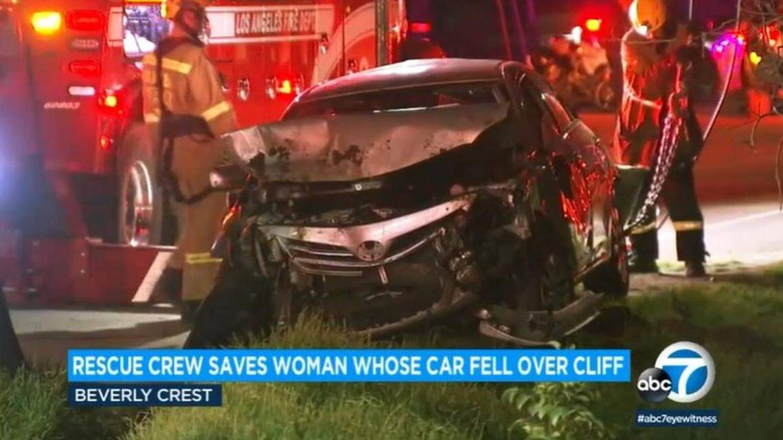 A car fell 100 feet off Mulholland Drive in Los Angeles, coming to rest against a tree, California firefighters say.