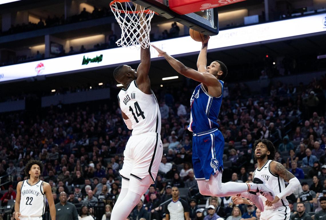 Sacramento Kings forward Keegan Murray (13) dunks against Brooklyn Nets forward Harry Giles III (14) during an NBA game at Golden 1 Center on Monday.