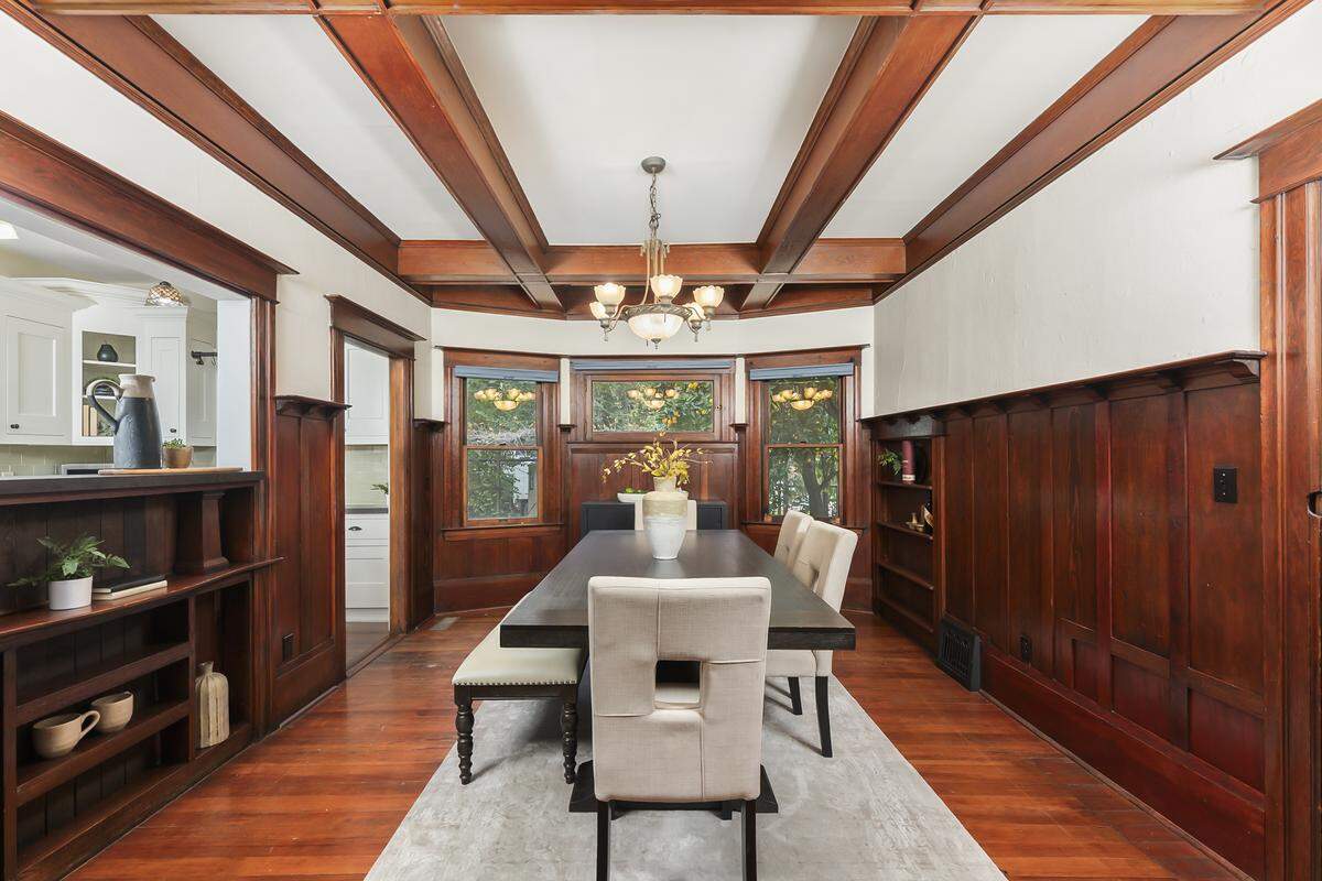 The dining room adjacent to the kitchen features a box wood ceiling and built-ins.