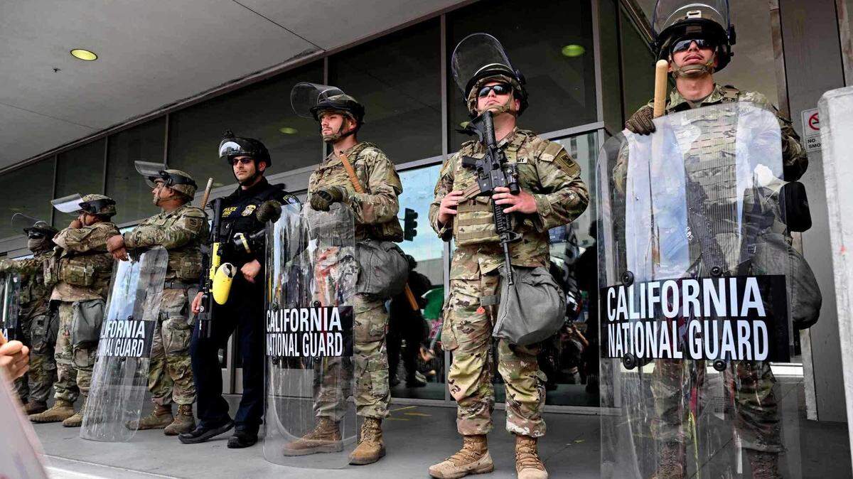 California National Guard personnel stand guard as protesters gather in front of the Edward R. Roybal Federal Building in Los Angeles in June 2025. A federal judge ruled Wednesday that the Trump administration’s extended control of the California Guard is illegal, temporarily blocking further deployments.