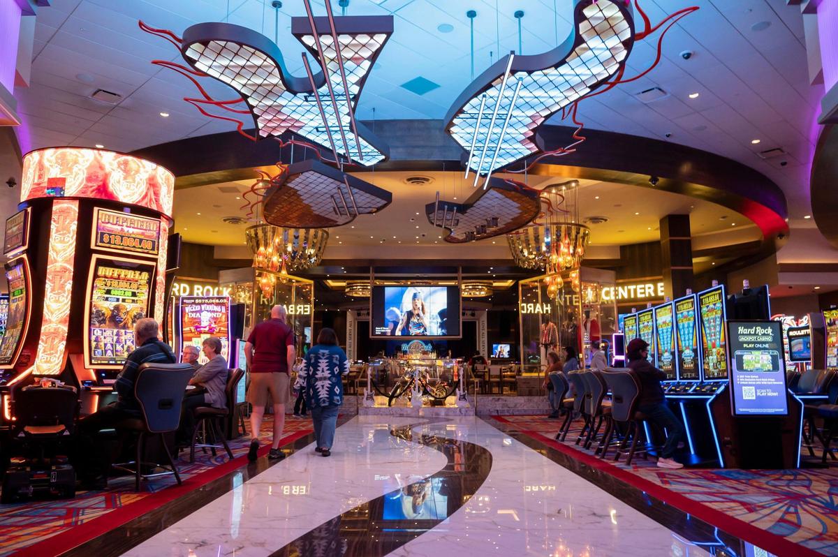 Guests walk towards the Hard Rock Cafe Center Bar while others play the slot machines at the Hard Rock Hotel and Casino in Yuba County on Monday.