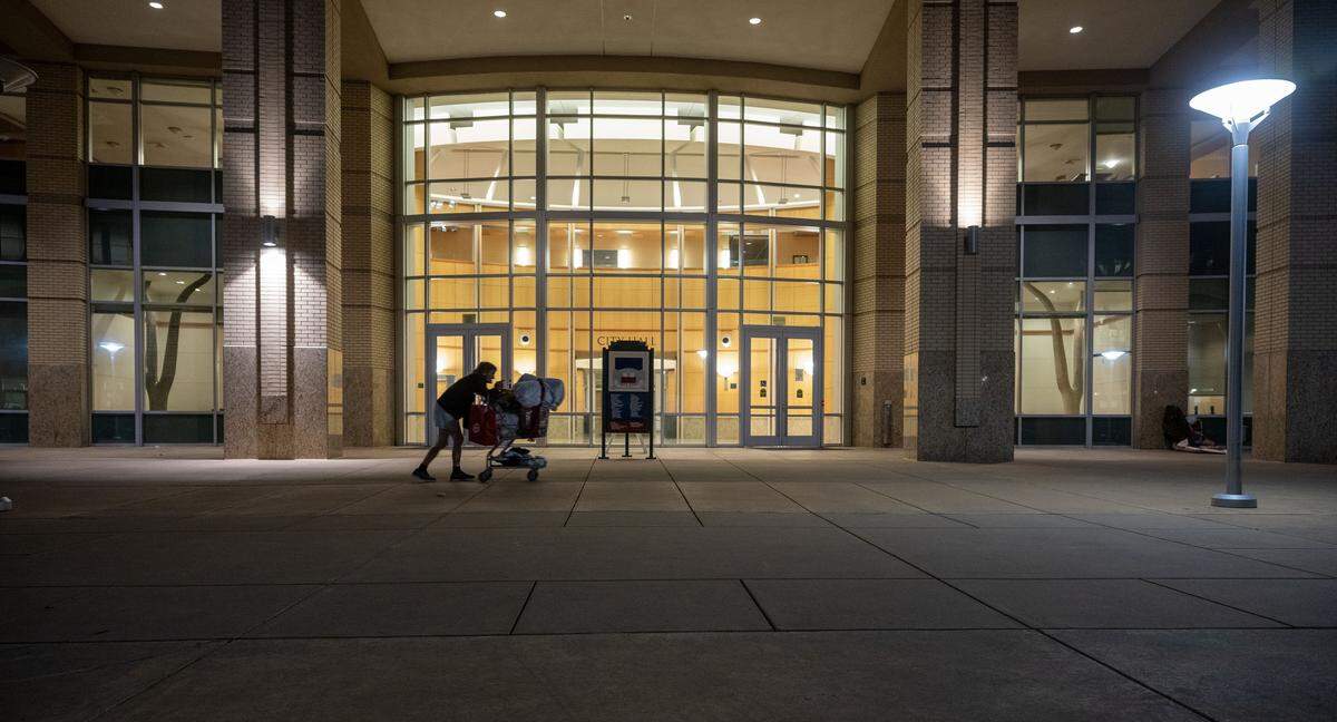 A homeless woman who declined to give her name walks aimlessly in front of Sacramento City Hall on Wednesday, the last night before an ordinance took effect prohibiting people from sleeping outside the facility.