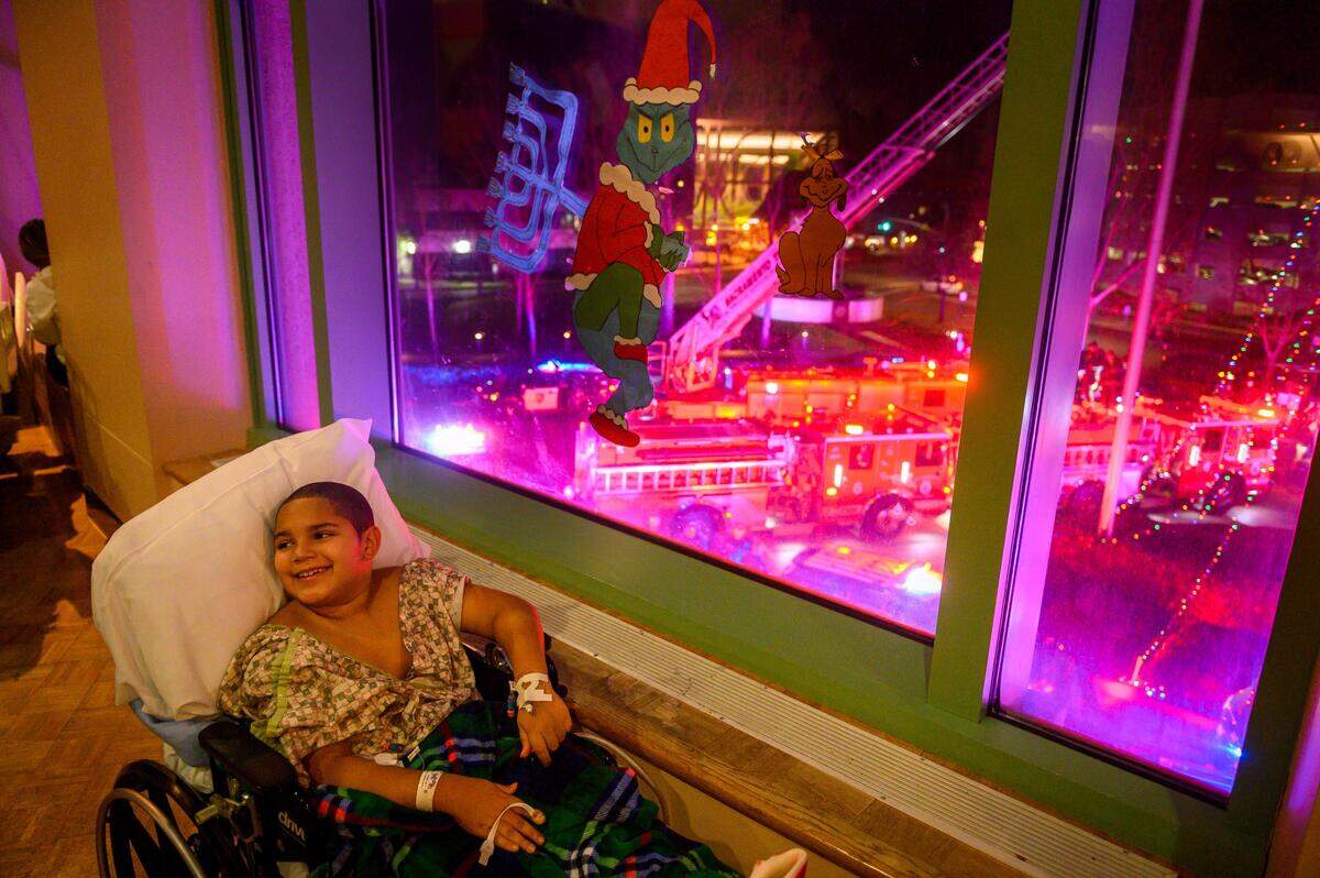 15. Keyon Hubbert, 8, looks back at parents as he delights in the “Good Night Lights” show where vehicles from various organizations illuminate the hospital at Shriner’s Hospital for Children in Sacramento on Tuesday, Dec. 17, 2019. Children from the hospital huddle together to see the light show on the second floor of the hospital. Keyon who has cerebral palsy came to the hospital to have his hardware removed from a previous hip surgery and had his orthopedic surgery to correct his feet in hopes to improved independent walking ability.